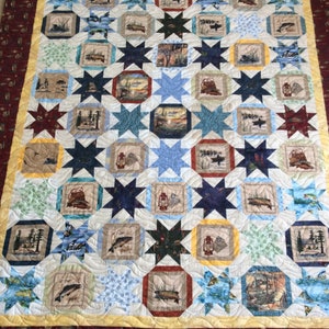 Peut inclure: Une courtepointe sur le thème de la pêche. La courtepointe est composée d'une grille de carrés avec une étoile dans chaque carré. Les carrés sont remplis d'images différentes sur le thème de la pêche, comme des poissons, des bateaux et du matériel de pêche. La courtepointe est bordée d'un tissu rouge et jaune.