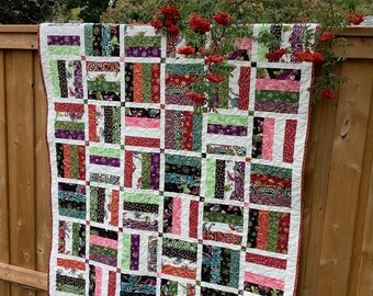 Modern Christmas lap quilt in bright jewel tones with white borders, sofa or bed throw blanket, snuggle under to read Xmas stories