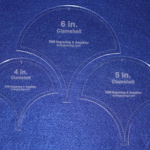 May include: Three clear plastic clamshell templates for sewing or crafting. The templates are 4 inches, 5 inches, and 6 inches in diameter. The templates are labeled with the size and "Clamshell".