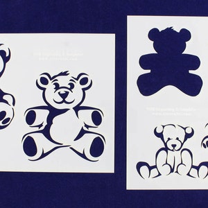 May include: A white stencil sheet with five different teddy bear designs. The designs include a teddy bear with a heart, a teddy bear with a simple outline, and a teddy bear with a more detailed design.