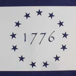 May include: A white stencil featuring a circle of 13 stars surrounding the number "1776" in a classic font. The stencil is on a dark blue background, evoking a patriotic theme.