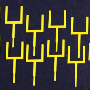 May include: Ten yellow metal tuning forks on a dark blue background.