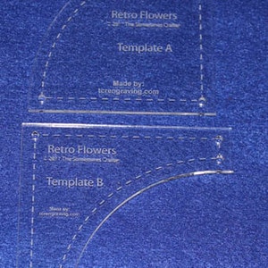 May include: Two clear acrylic quilting templates for the Retro Flowers quilt pattern. Template A and Template B are labeled on the templates. The templates are made by tcrengraving.com.