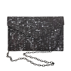 Pode incluir: Clutch preta e branca com padr&atilde;o e al&ccedil;a de corrente prateada.