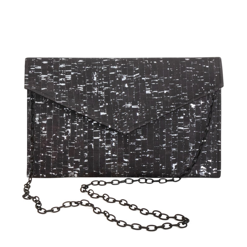 Pode incluir: Clutch preta e branca com padr&atilde;o e al&ccedil;a de corrente prateada.