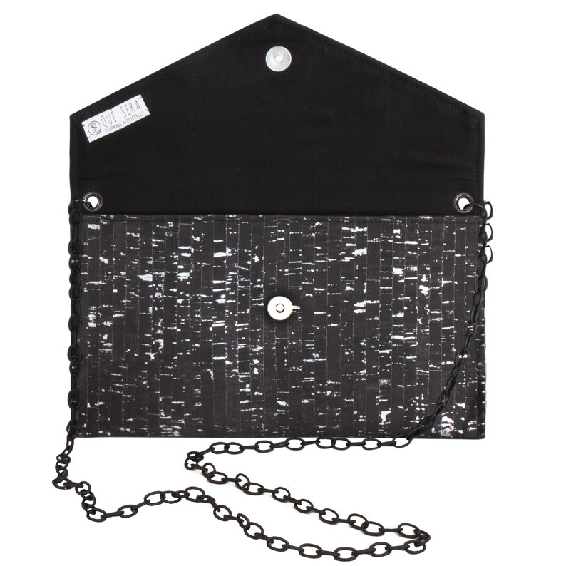 Pode incluir: Clutch preta de corti&ccedil;a com uma al&ccedil;a de corrente prateada. A clutch tem um forro de tecido preto e um pequeno fecho de bot&atilde;o prateado. A clutch tem uma etiqueta que diz "Que Sera Handmade Accessories".
