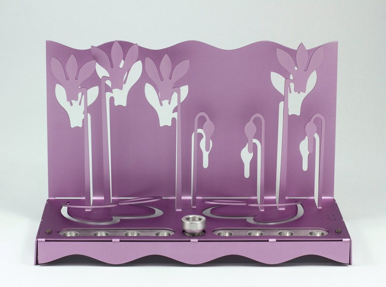 May include: A purple metal menorah with a floral design. The menorah has nine candle holders and a central shamash holder.