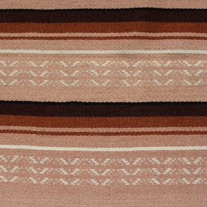 May include: A woven rug with a striped pattern in shades of brown, pink, and white. The rug has a geometric design with a repeating pattern of small triangles.