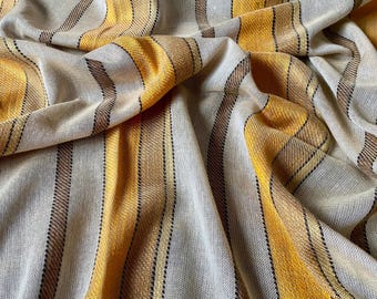 May include: A beige and yellow striped fabric with a woven texture. The fabric is folded and draped, showing the stripes and texture.