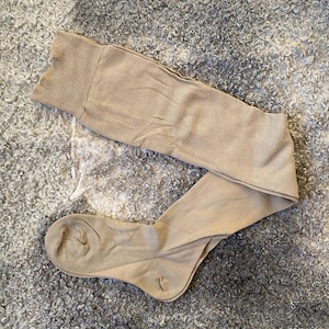 Puede incluir: Un par de calcetines de color carne hasta la rodilla hechos de un tejido suave y elástico.