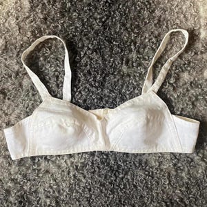 Op de afbeelding: Een witte katoenen bh met verstelbare bandjes. De bh heeft een simpel ontwerp met een gladde, naadloze afwerking.