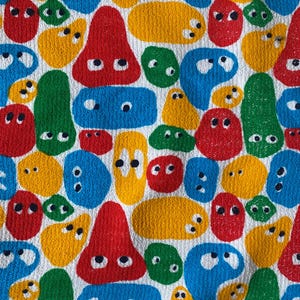 Pu&ograve; includere: Motivo tessile colorato con varie forme astratte rosse, gialle, blu e verdi, ciascuna con due piccoli dettagli neri a forma di occhi. Le forme sono disposte su uno sfondo bianco, creando un design giocoso e vivace.