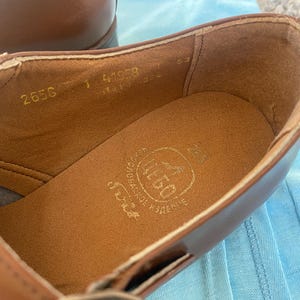 May include: Close-up of the inside of a brown leather shoe with the text "2656 1 41969" and "SCHOOL SHOES" printed on the insole.