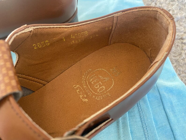 May include: Close-up of the inside of a brown leather shoe with the text "2656 1 41969" and "SCHOOL SHOES" printed on the insole.