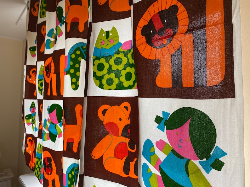 May include: A brown and white fabric with a repeating pattern of colorful animals and people. The animals include a lion, a bear, a cat, and a horse. The people are wearing colorful clothes and have different hairstyles.