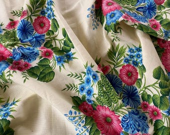 May include: Cream-colored fabric with a repeating pattern of blue and pink flowers with green leaves.