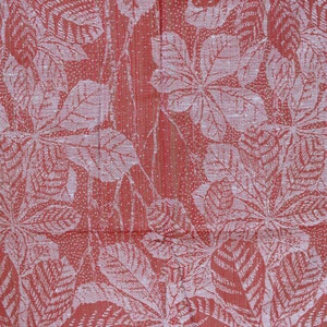 May include: Red fabric with a white embossed pattern of leaves. The leaves are arranged in a repeating pattern.