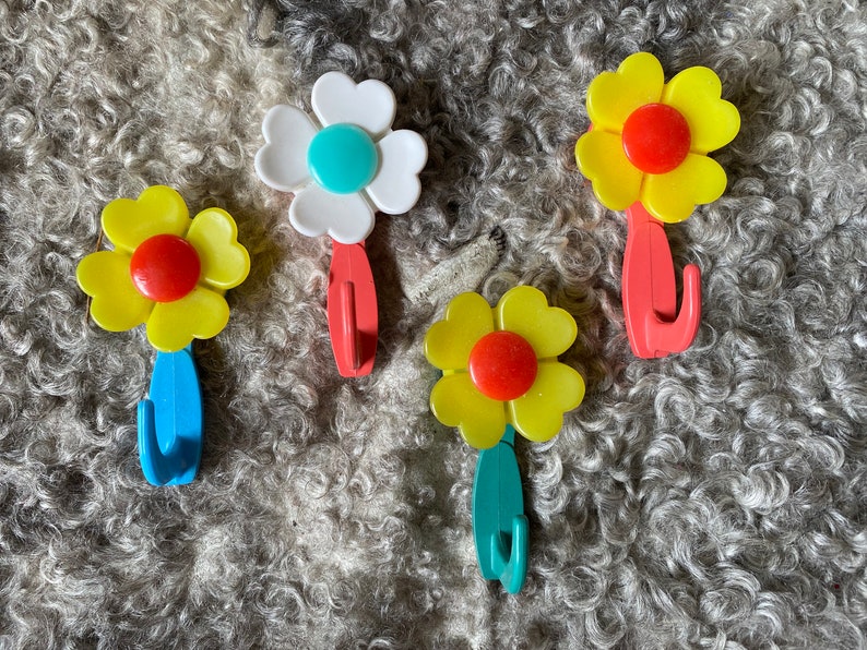 May include: Four flower-shaped hooks in yellow, white, and red with blue, green, and red hooks.