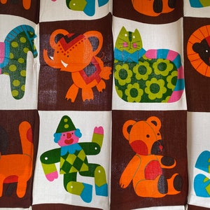 May include: A colorful fabric with a repeating pattern of various animal illustrations. The animals include a horse, elephant, cat, lion, dog, clown, bear, and a girl. The fabric is brown, orange, green, blue, pink, and white.
