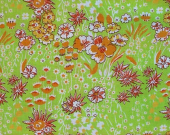 May include: A green fabric with a floral pattern. The flowers are orange, yellow, and white. The fabric has a vintage feel.