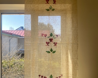 May include: A beige linen curtain with a floral pattern of red and green bleeding hearts. The curtain is hanging in a window with a view of a house and trees.