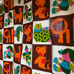 May include: A brown and white fabric with a repeating pattern of colorful animals and figures. The animals include a lion, a cat, a bear, and a horse. The figures include a clown and a girl.