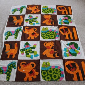 May include: A brown and white fabric with a repeating pattern of colorful animals. The animals include a horse, elephant, cat, lion, dog, and a clown. The fabric is perfect for a baby quilt or other sewing projects.