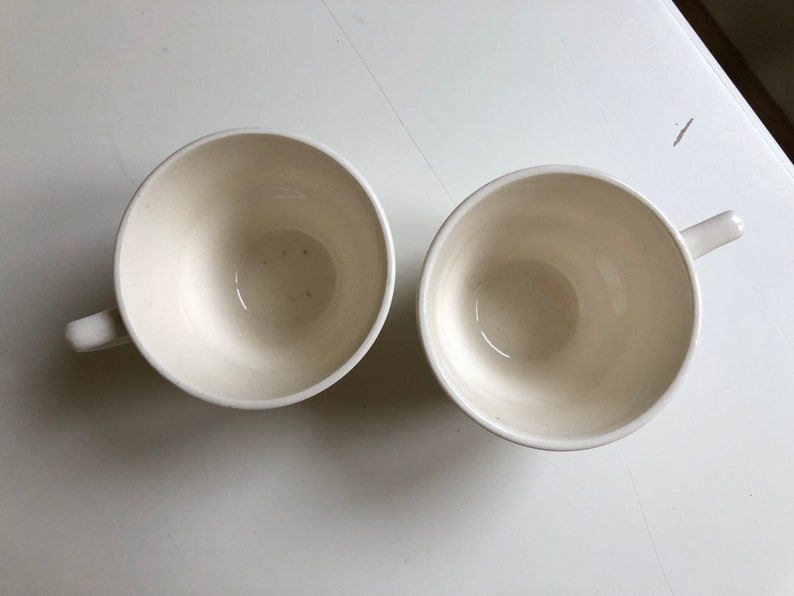 Peut inclure: Deux tasses &agrave; caf&eacute; en c&eacute;ramique blanche avec un design simple. Les tasses sont vides et ont une finition lisse et brillante.