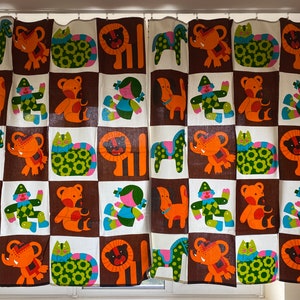 May include: A pair of brown and white curtains with a checkered pattern featuring colorful cartoon animals and figures. The animals include a lion, elephant, cat, and horse. The figures include a clown and a girl.