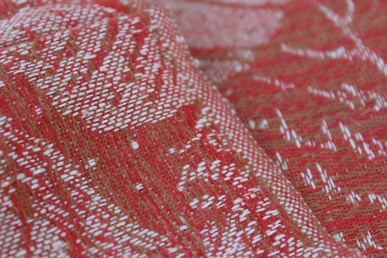 May include: Close-up of a red and white woven fabric with a textured pattern. The fabric has a soft, fuzzy texture.