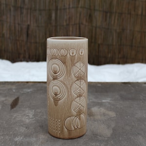 K&ouml;nnte beinhalten: Eine Keramikvase mit hellbrauner Glasur und einem geometrischen Muster aus Kreisen und Ringen.