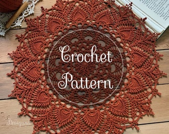 May include: A close-up of a crocheted doily in a rust orange colour. The doily is circular and has a delicate, intricate design. The text "Crochet Pattern" is superimposed on the doily.
