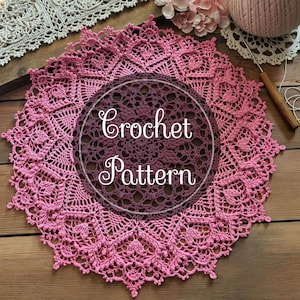 May include: A pink crochet doily with a delicate pattern. The doily has a centre circle with the text "Crochet Pattern" in a cursive font.
