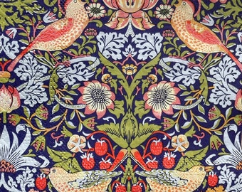 Op de afbeelding: Een vintage-stijl stof met een herhalend patroon van gestileerde vogels, bloemen en bladeren. Het ontwerp is in tinten rood, geel, groen en wit op een donkerblauwe achtergrond.
