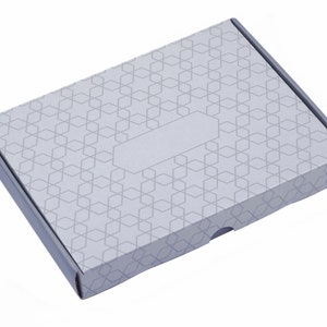 K&ouml;nnte beinhalten: Ein grauer Karton mit geometrischem Muster und einem leeren Etikett. Die Schachtel hat eine Klappe, die sich &ouml;ffnen l&auml;sst, um den Inhalt zu enth&uuml;llen.