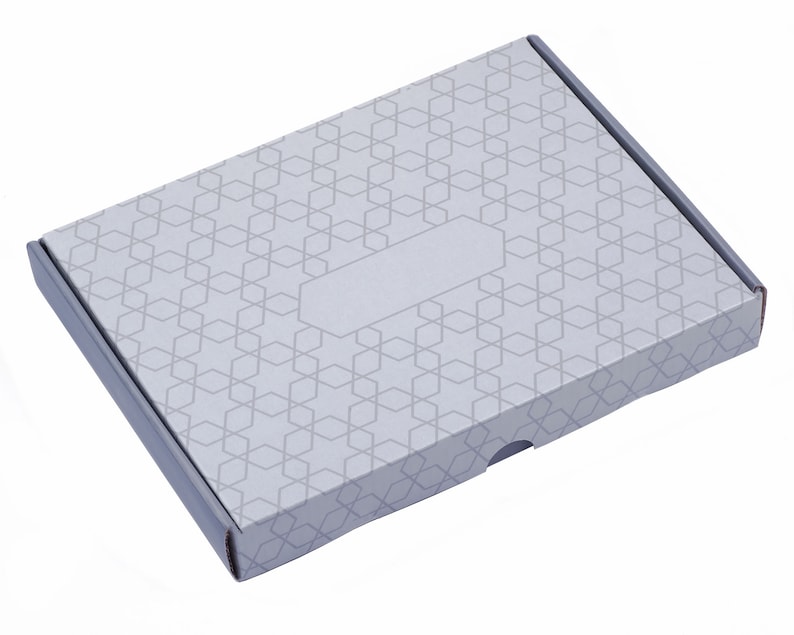 K&ouml;nnte beinhalten: Ein grauer Karton mit geometrischem Muster und einem leeren Etikett. Die Schachtel hat eine Klappe, die sich &ouml;ffnen l&auml;sst, um den Inhalt zu enth&uuml;llen.