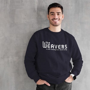 以下が含まれることがあります： 白い文字で「the WEAVERS a new comedy from david sealy」と書かれた紺色のスウェットシャツです。