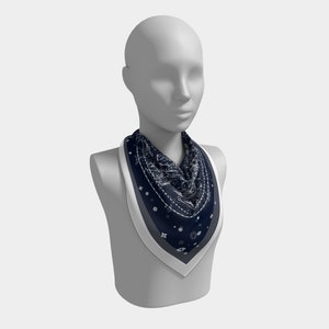 May include: A navy blue bandana with a white pattern, worn around the neck of a mannequin.
