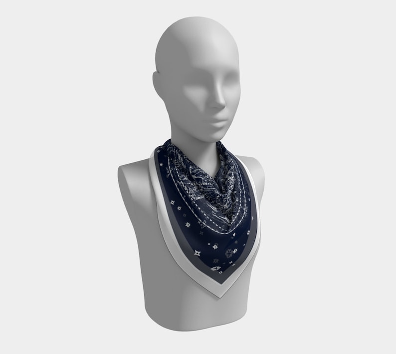 May include: A navy blue bandana with a white pattern, worn around the neck of a mannequin.