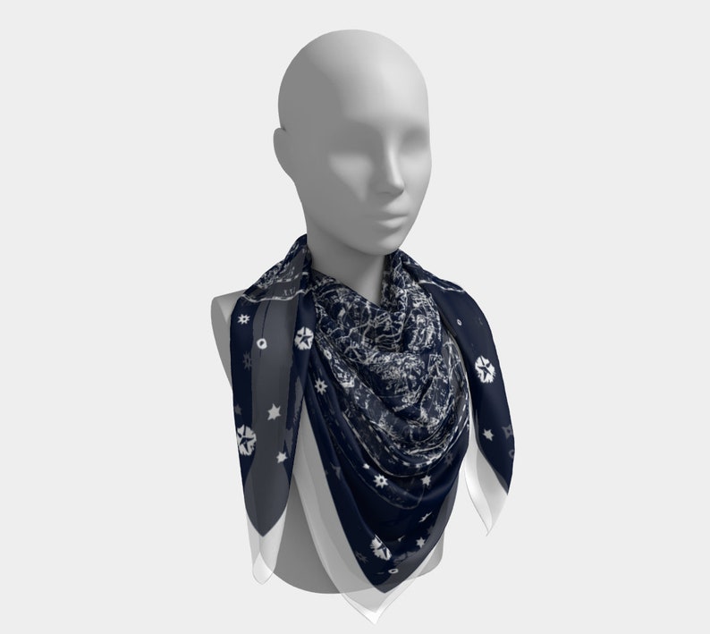 May include: A navy blue and white patterned scarf with a geometric design. The scarf is folded and draped around a mannequin's neck.