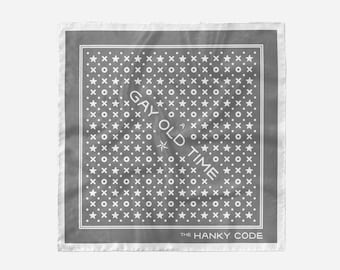 May include: A square, gray handkerchief with a white border and a pattern of stars, dots, and XOXO symbols. The text "GAY OLD TIME" is printed diagonally across the center. The text "THE HANKY CODE" is printed at the bottom.