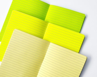 May include: Three notebooks with lined pages. The top notebook is green, the middle notebook is yellow, and the bottom notebook is a pale yellow.