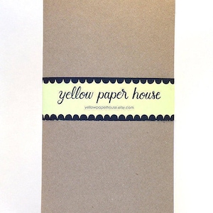 Puede incluir: Un cuaderno marr&oacute;n con una etiqueta amarilla y negra que dice "yellow paper house" y "yellowpaperhouse.etsy.com".