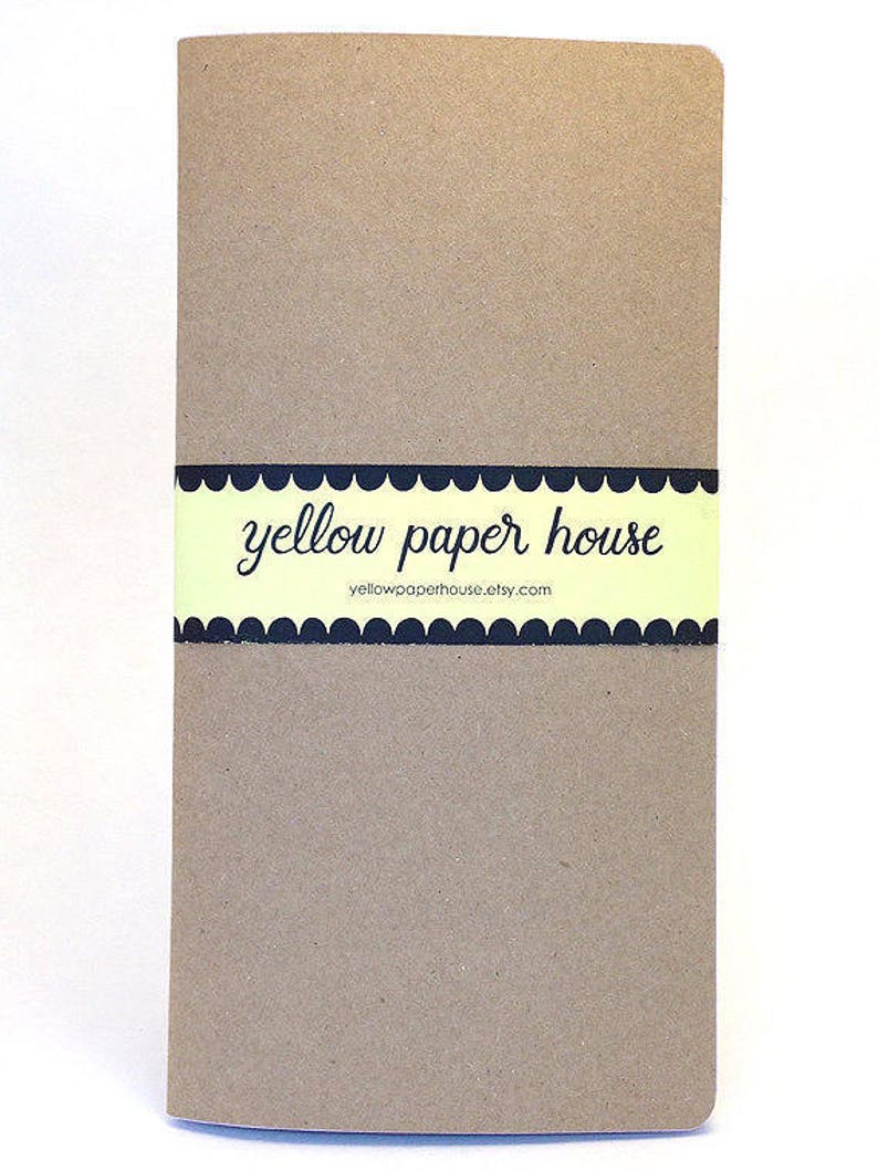 Puede incluir: Un cuaderno marr&oacute;n con una etiqueta amarilla y negra que dice "yellow paper house" y "yellowpaperhouse.etsy.com".
