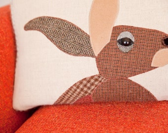 Handmade Autumn Hare cushion with brown and rust check wools.