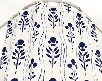 Puede incluir: Cortina de ducha blanca con un patrón repetido de diseños florales estilizados en azul marino. Los elementos florales incluyen cabezas de flores redondas y hojas largas y delgadas. Líneas punteadas en azul marino crean un patrón vertical ondulado.