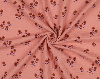 May include: A close-up of a pink fabric with a floral pattern. The fabric has a crinkled texture and is adorned with clusters of brown flowers and purple leaves. The flowers are evenly spaced across the fabric.