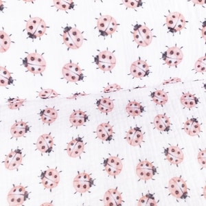 Pode incluir: Tecido branco com um padrão repetido de joaninhas cor-de-rosa. As joaninhas estão espalhadas aleatoriamente pelo tecido.