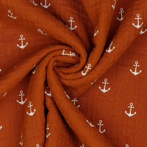Könnte beinhalten: Ein rostfarbener Stoff mit einem weißen Ankermuster. Der Stoff ist gefaltet und strukturiert.