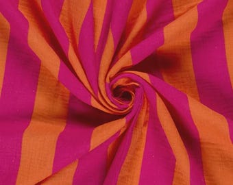 May include: A piece of fabric featuring a repeating vertical stripe pattern in alternating shades of vibrant magenta pink and bright orange. The textile is gathered in the center, creating a spiral effect that highlights the texture of the weave.